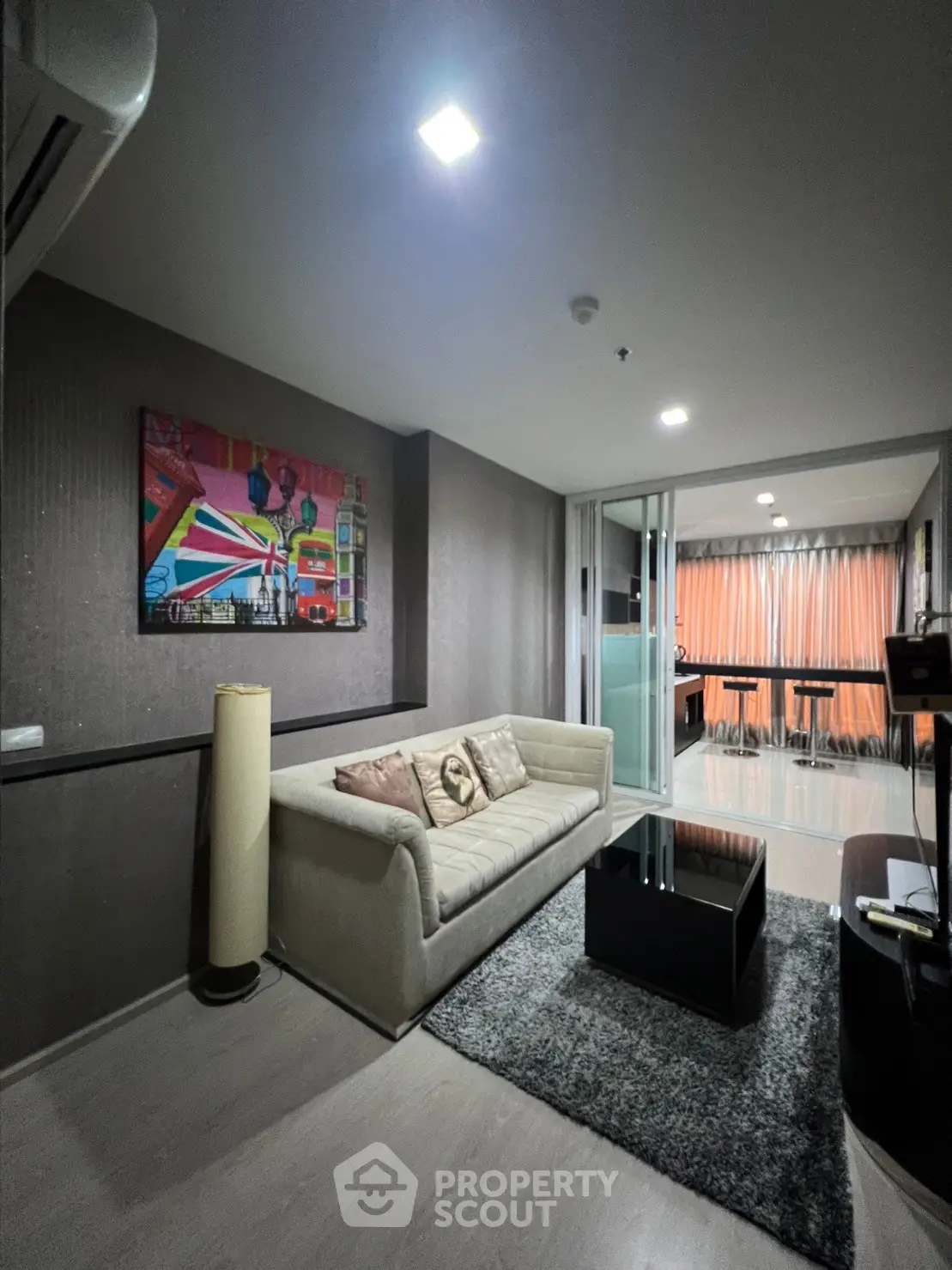Modern living room with stylish decor and cozy ambiance, featuring a comfortable sofa and contemporary artwork.