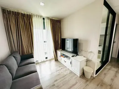 Modern living room with sleek design, featuring a cozy sofa, large TV, and floor-to-ceiling windows with elegant curtains.