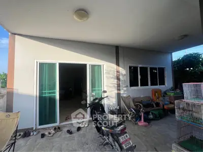 Spacious covered patio with sliding glass doors and ample natural light, perfect for outdoor relaxation.