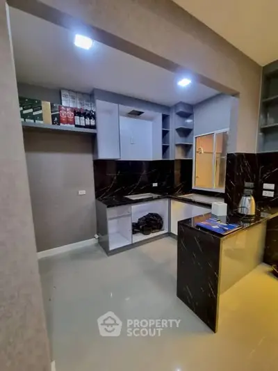 Modern kitchen with sleek black countertops and open shelving