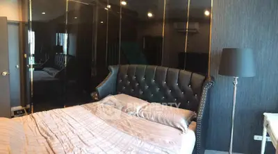 Luxurious bedroom with elegant black leather headboard and mirrored wardrobe