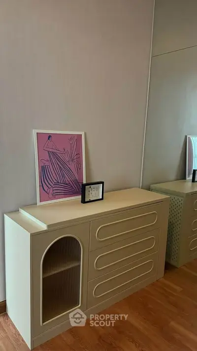 Stylish modern dresser with decorative art in a chic interior setting.