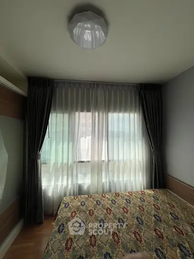 Cozy bedroom with elegant curtains and patterned bedspread