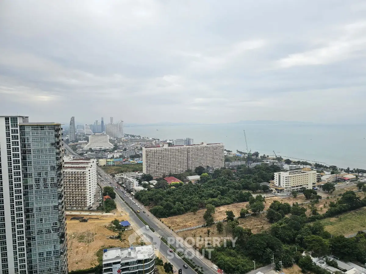 Stunning cityscape view from high-rise building overlooking the ocean and urban skyline.