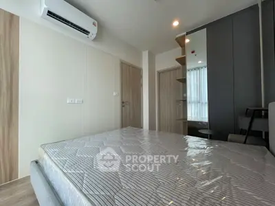Modern bedroom with air conditioning and stylish decor, featuring a comfortable bed and sleek wardrobe.