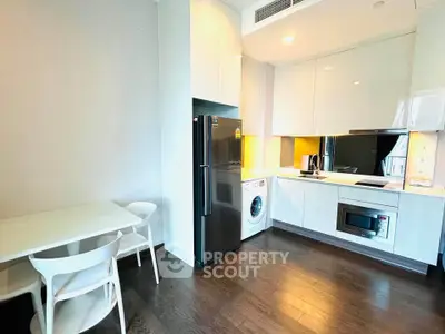 Modern kitchen with sleek appliances and dining area in stylish apartment