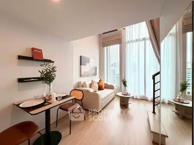 Modern living room with high ceilings and large windows offering city views, featuring cozy seating and stylish decor.