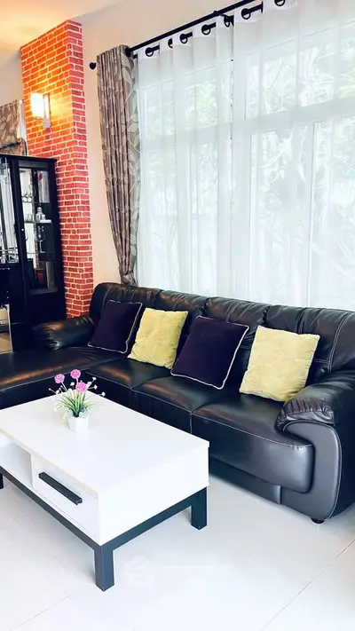 Stylish living room with leather sofa, modern coffee table, and large window with elegant curtains.