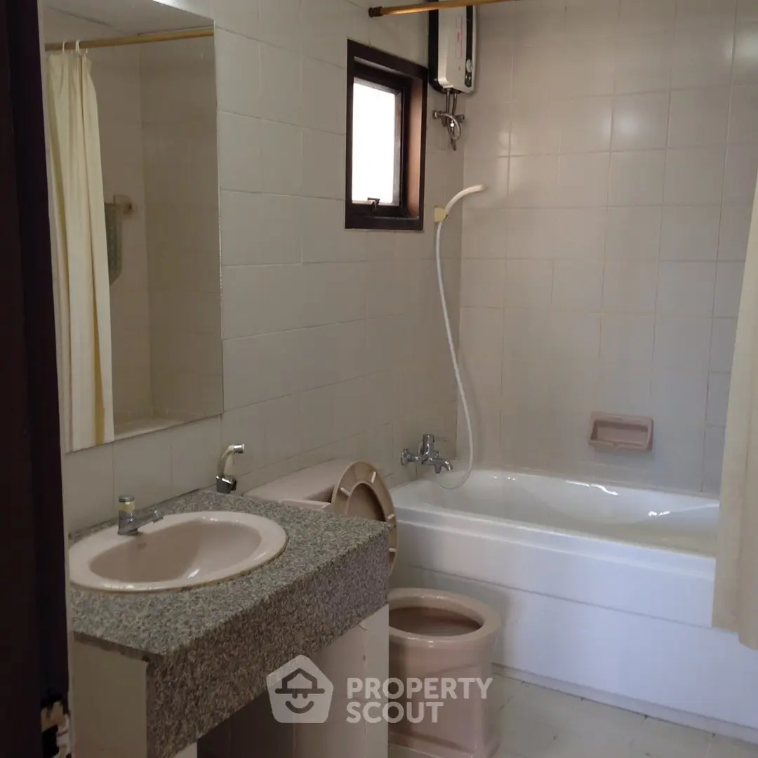 Spacious bathroom with bathtub and modern fixtures in a stylish apartment.