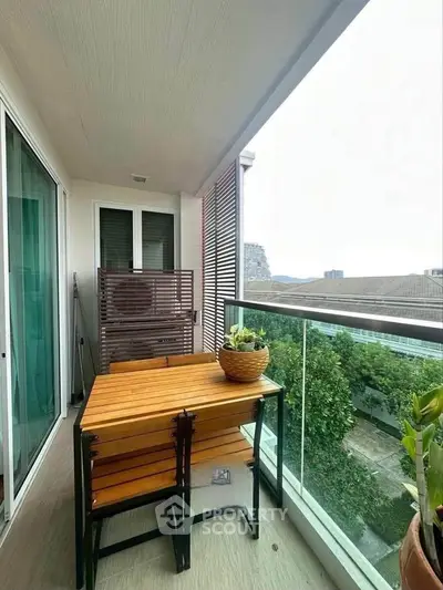 Charming balcony with modern furniture and lush greenery view, perfect for relaxation and outdoor dining.