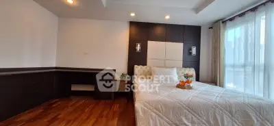 Spacious bedroom with modern design and large window offering city views.