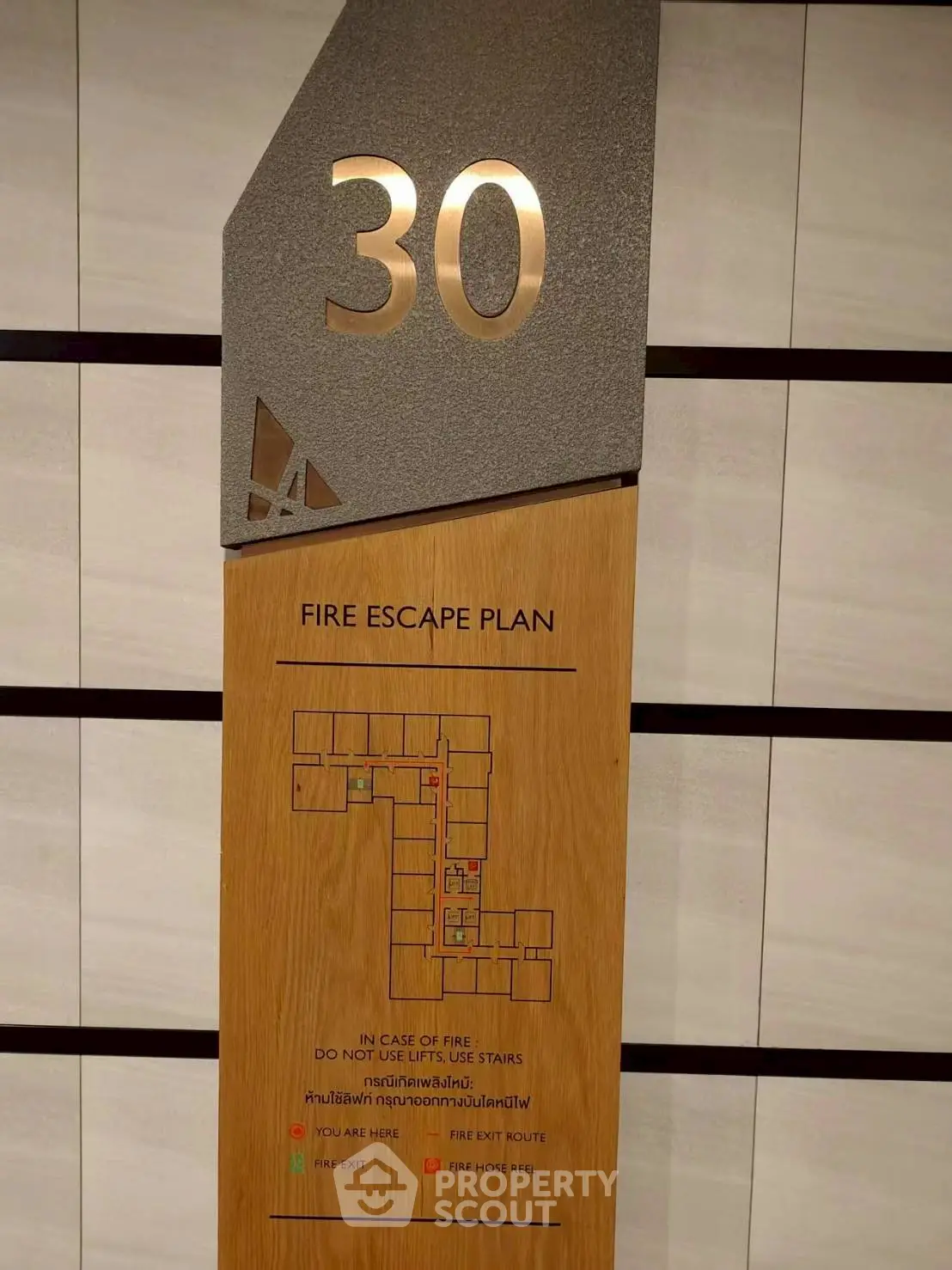 Modern fire escape plan sign on a building's 30th floor, showcasing safety features and layout.