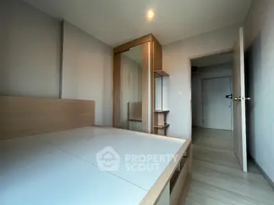 Modern minimalist bedroom with sleek wooden furniture and ample storage space.