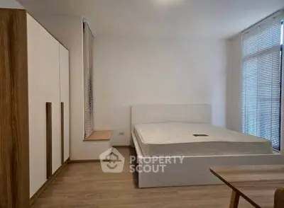 Spacious modern bedroom with minimalist design and large windows for natural light.