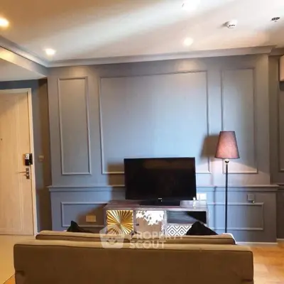 Stylish living room with modern decor and flat-screen TV, perfect for relaxation.