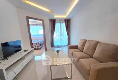 Modern living room with cozy sofa and sleek TV unit, leading to a bright bedroom.