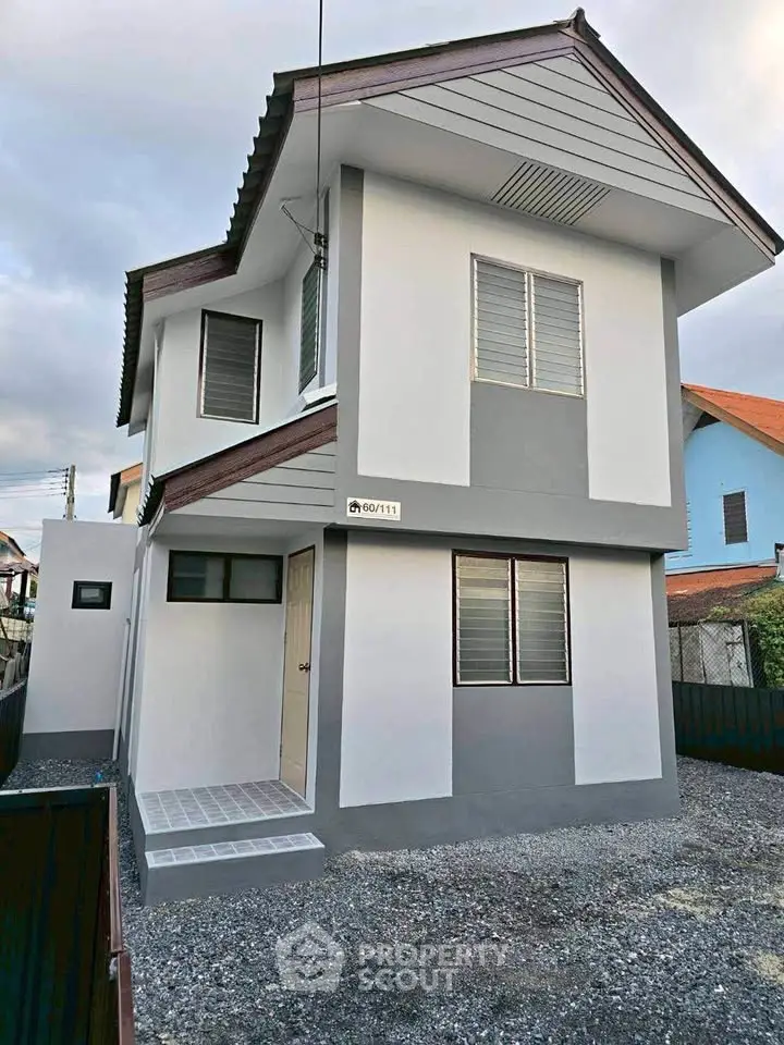 Modern two-story house with sleek design and neutral colors, featuring large windows and a spacious exterior.