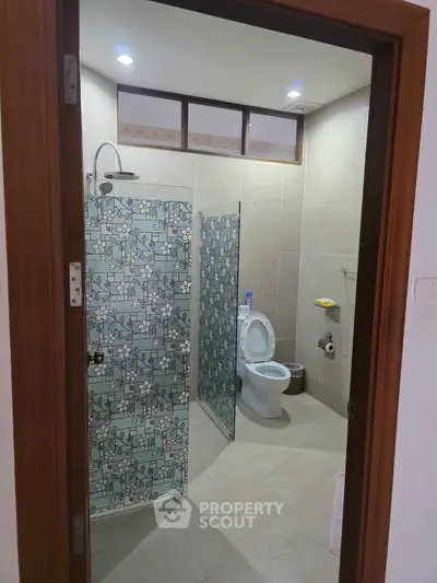 Modern bathroom with floral glass shower partition and sleek fixtures