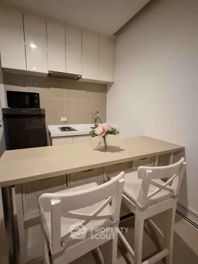 Modern kitchen with sleek cabinets and breakfast bar seating for two.