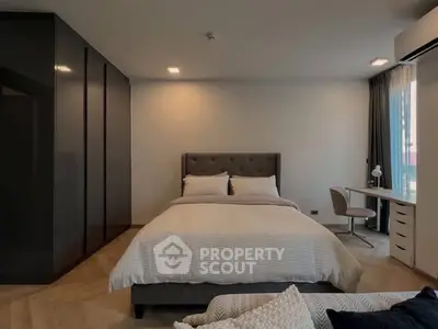 Modern bedroom with sleek design, featuring a cozy bed and stylish workspace by the window.