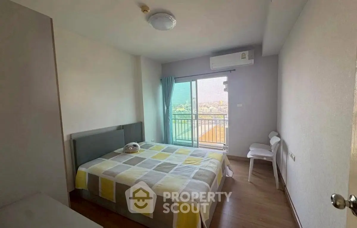 Cozy bedroom with balcony and air conditioning, featuring a comfortable bed and modern decor.