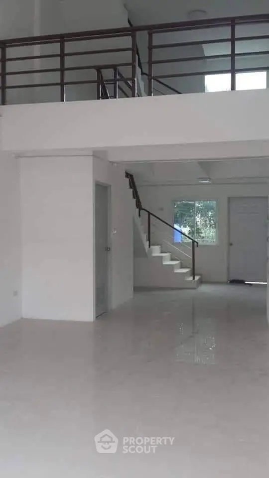 Spacious modern interior with high ceilings and sleek staircase, perfect for contemporary living.