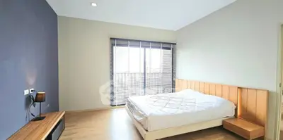 Spacious bedroom with modern design and large window for natural light.