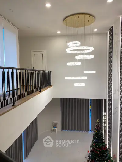 Luxurious modern living room with high ceilings and elegant chandelier, perfect for holiday gatherings.