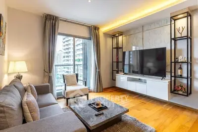 Modern living room with large TV and stylish decor in a high-rise apartment.