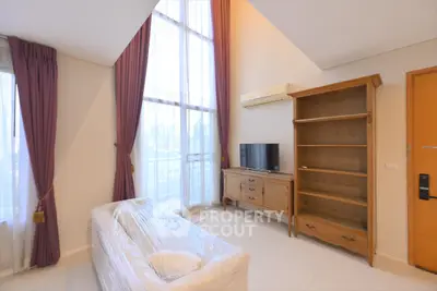 Spacious living room with high ceilings and elegant furnishings in a modern apartment.