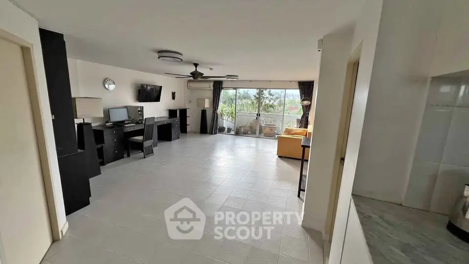 Spacious living room with modern decor and large windows offering natural light.