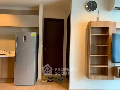 Modern kitchen with sleek fridge and wooden shelving in a stylish apartment