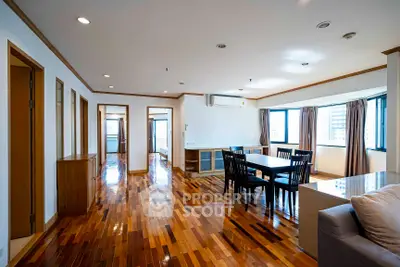 Spacious modern living room with hardwood floors and large windows.