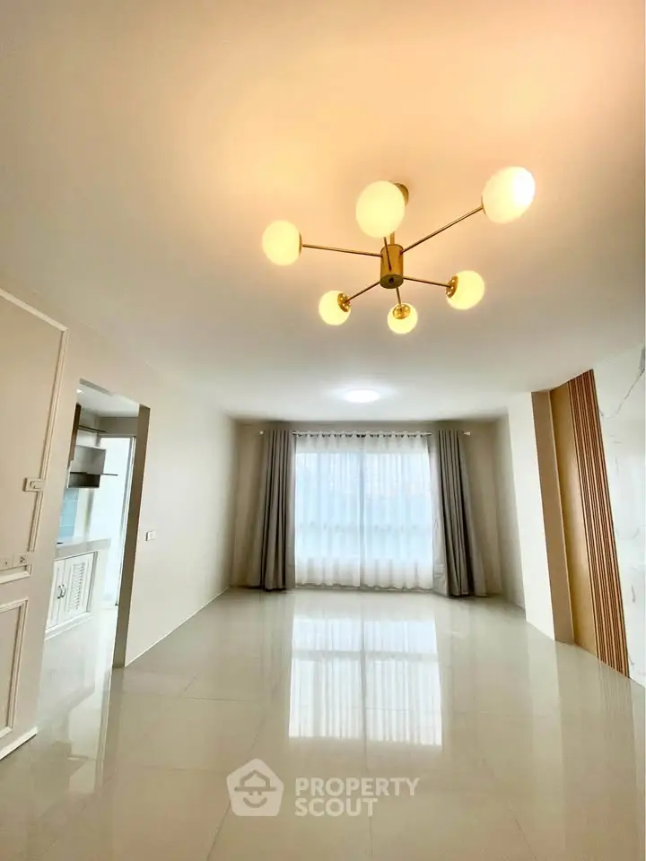 Spacious modern living room with elegant lighting and large windows.