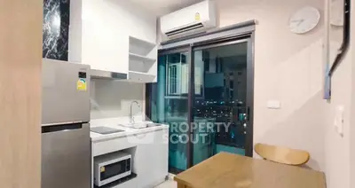 Modern compact kitchen with city view, featuring sleek appliances and stylish dining area.
