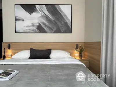 Modern bedroom with a large comfortable bed, stylish wooden headboard, elegant bedside lamps, and a striking abstract painting above the bed.