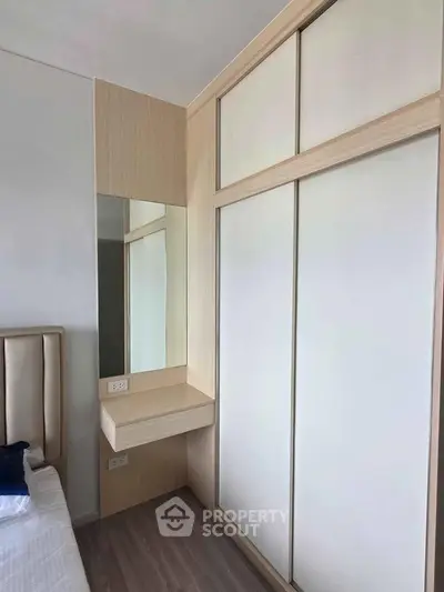 Modern bedroom with sleek built-in wardrobe and stylish vanity mirror
