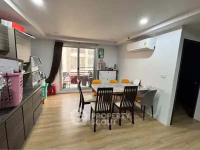 Modern dining area with wooden flooring and balcony access