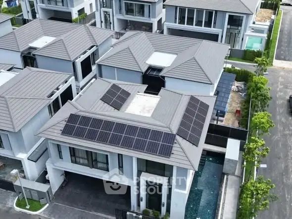 Modern residential complex with solar panels and private pool, showcasing sustainable living.