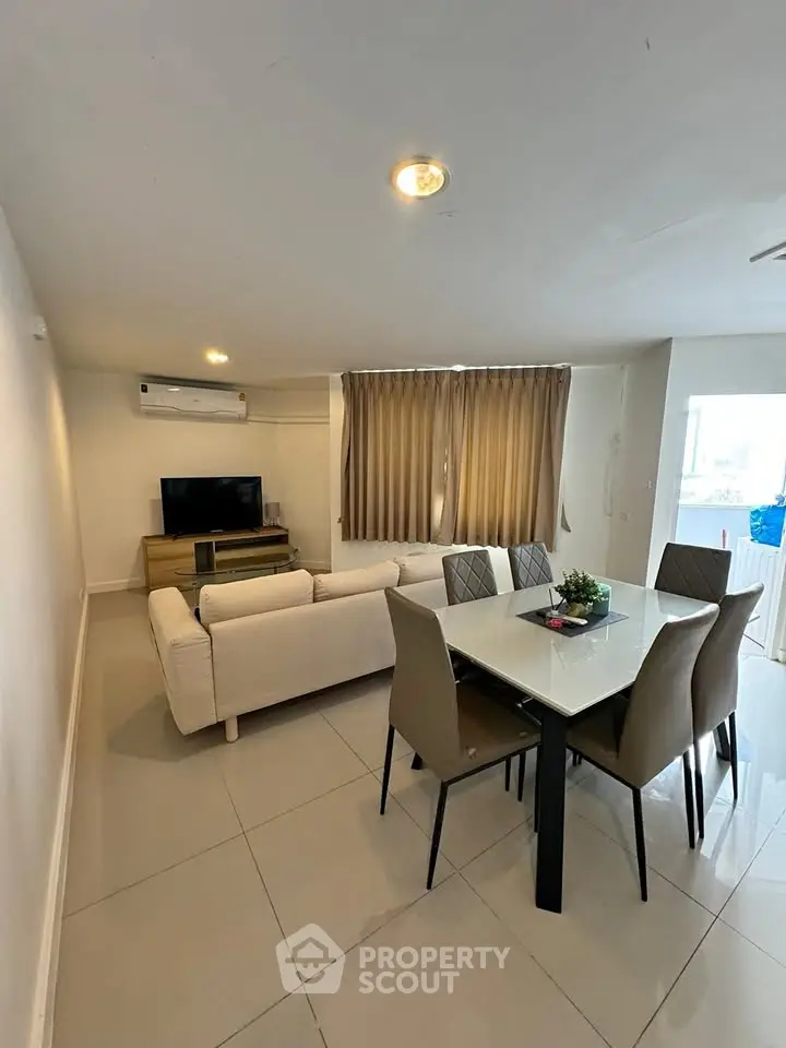 Spacious living room with modern furniture and dining area, perfect for family gatherings.