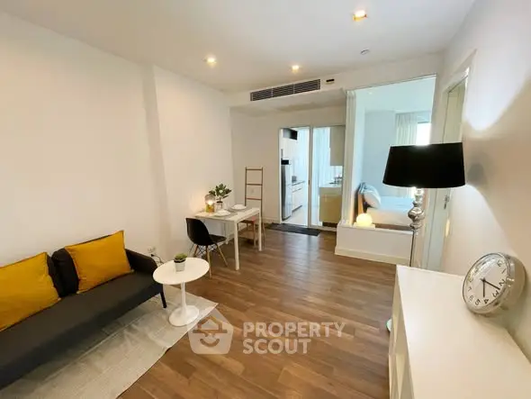 Modern living room with stylish decor and open layout leading to bedroom