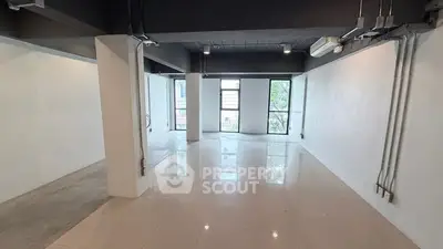 Spacious open-plan interior with large windows and modern finishes, ideal for versatile living or office space.
