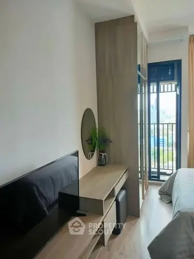 Modern bedroom with TV and balcony view in stylish apartment