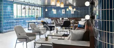 Stylish modern lounge with blue tiled walls and elegant seating, perfect for relaxation and social gatherings.