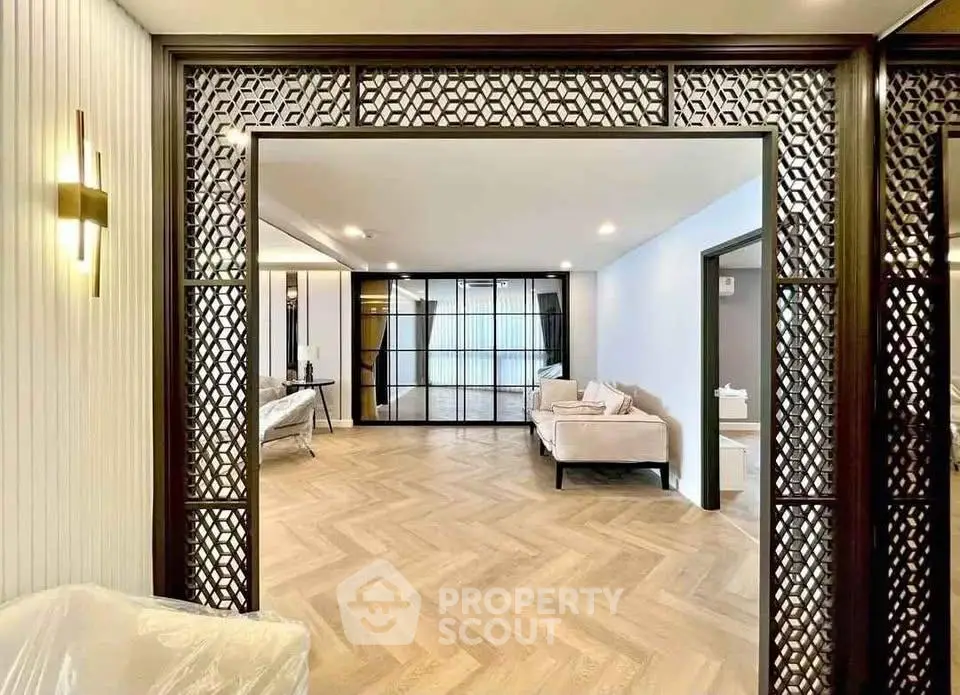 Spacious modern living room with elegant wooden flooring and stylish partition design.