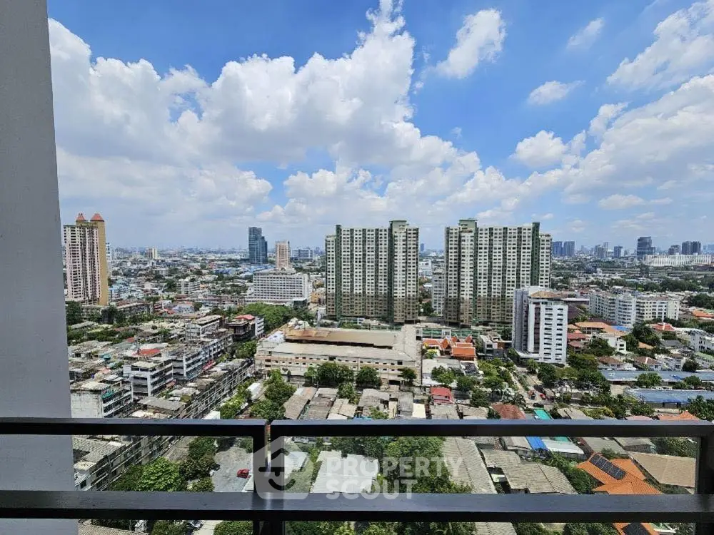 Stunning cityscape view from high-rise balcony with clear blue sky.