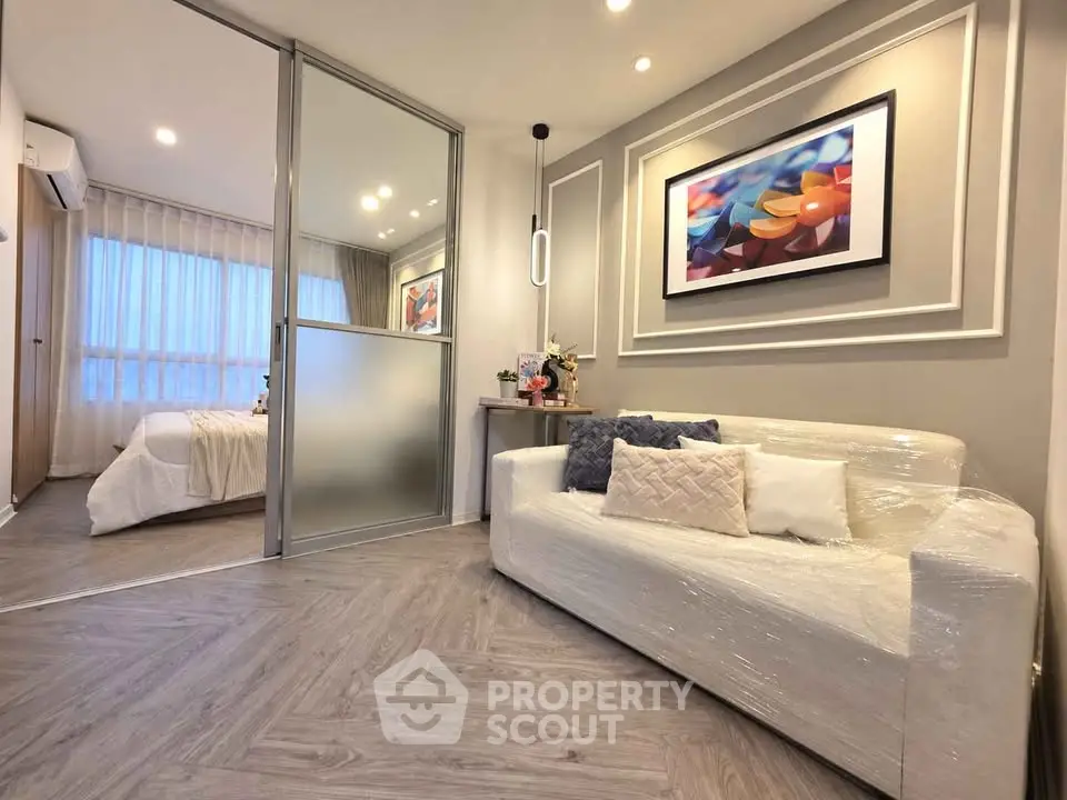 Modern living room with elegant decor and cozy bedroom view, featuring stylish furniture and ambient lighting.