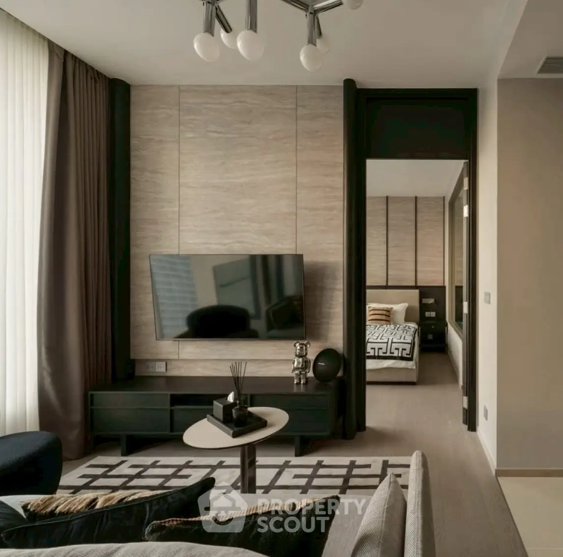 Modern living room with stylish decor and view into cozy bedroom