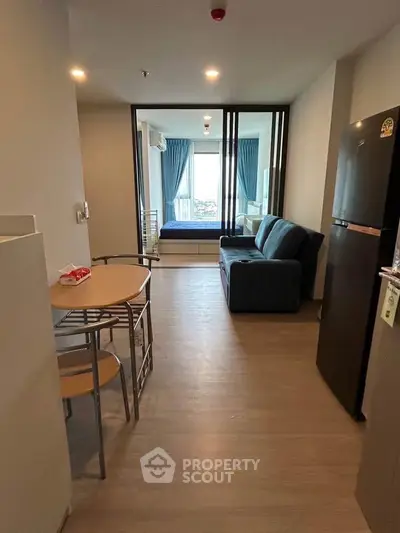 Modern apartment interior with open layout, featuring a cozy living area and dining space.