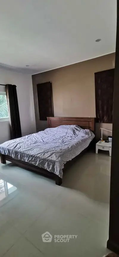 Spacious bedroom with natural light and modern furnishings